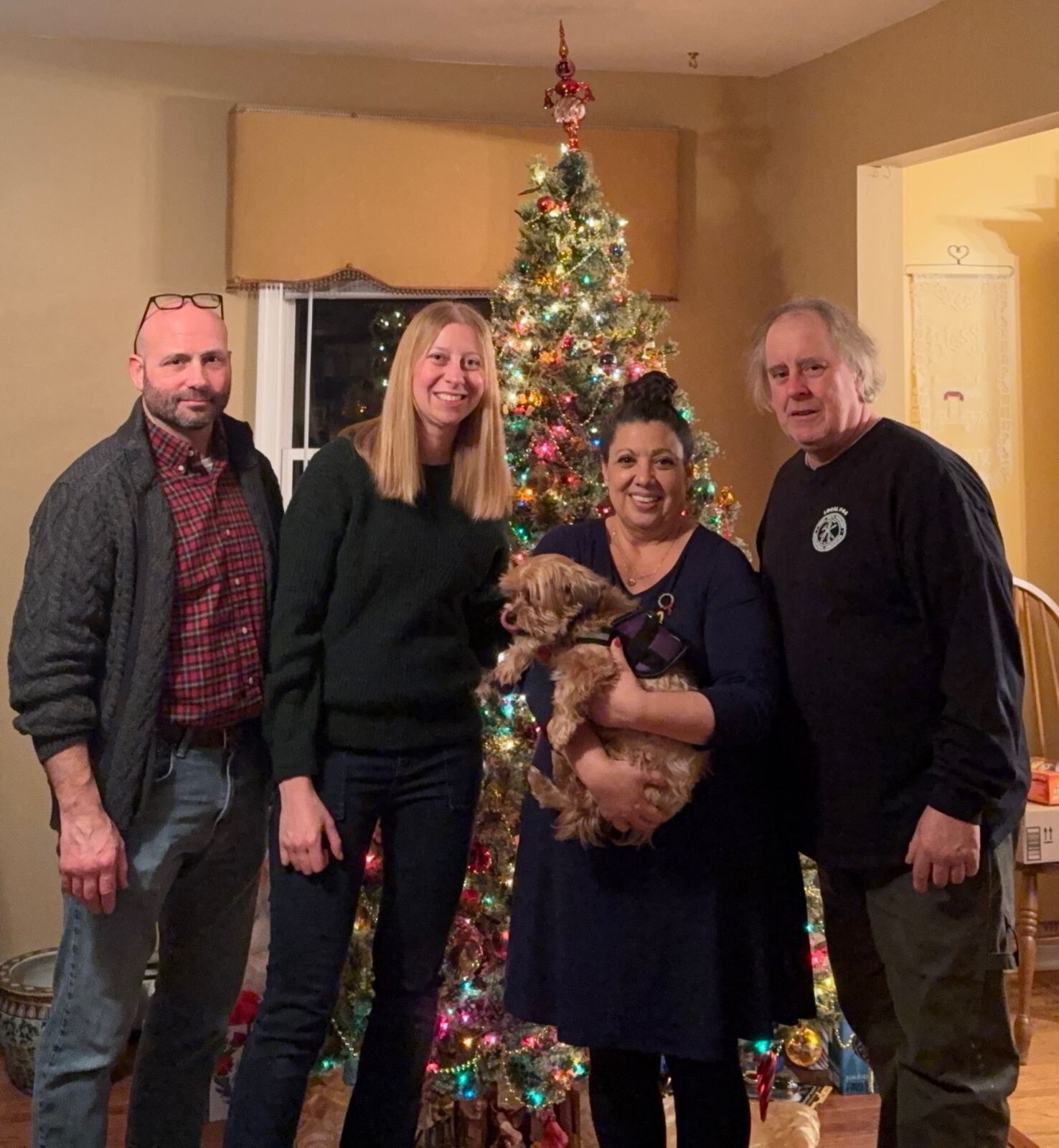 Tom and Maria with family celebrating the holidays in front of a Christmas tree